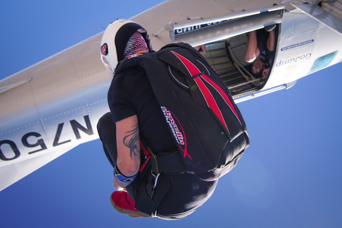 woman tucks in freefall wearing black and red Javelin Odyssey and white helmet