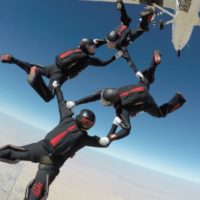 experienced formation skydiving team exits plane wearing Sun Path rigs